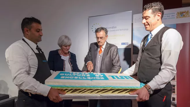 TUM-Präsident Herrmann und die Beauftragte für Strategische Internationale Allianzen der TUM schneiden gemeinsam den Geburtstagskuchen an.
