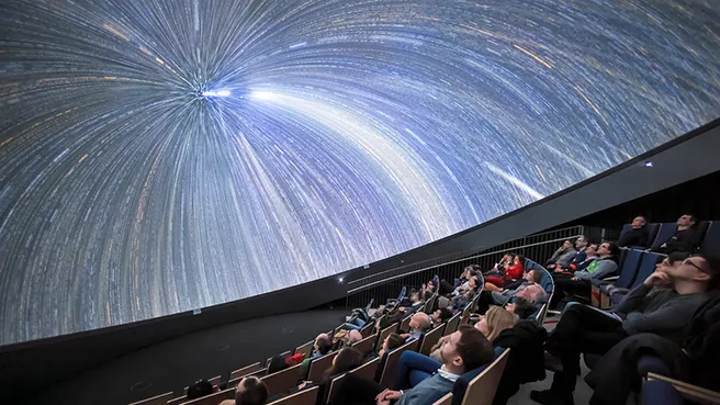 Planetarium-Show in der ESO Supernova: Zuschauer unter faszinierendem Sternenhimmel