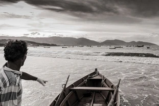 Monochrome picture of a man making his boat ready to go fishing