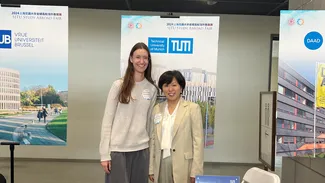 Die zwei Vertreterinnen der TUM vor Plakaten auf der Messe