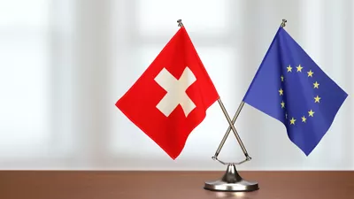 Wimpel der EU und der Schweiz auf einem Schreibtisch