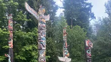 Totem poles amidst numerous trees
