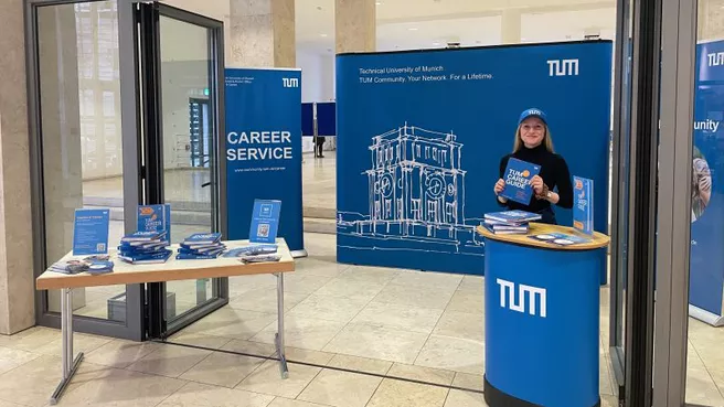 TUM Career Service employee at a trade fair booth