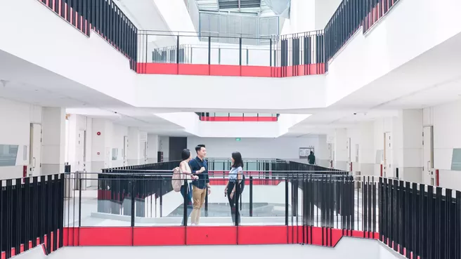 Three students talking in a stairwell