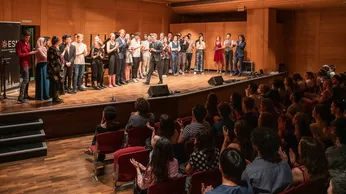 Gruppenbild der Veranstaltenden und Musiker:innen auf der Bühne