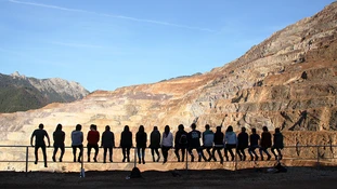 A group of exchange students sitting on a fence, enjoying the view of the Erzberg