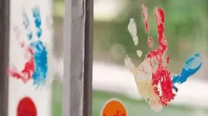 Children's handprints applied to a windowpane with windowpaint