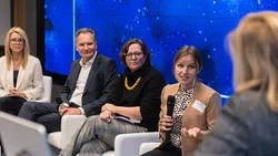 Foto von vier Panelisten und der Moderatorin auf der Bühne