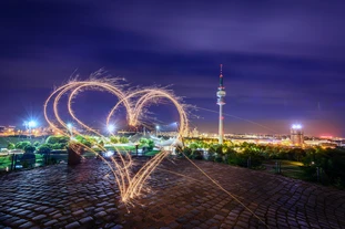 Heart-shaped fireworks in front of the nightly scenery  of the Munich Olympic Park