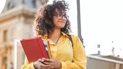 Junge Frau mit Büchern auf dem Arm