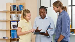 Two students receive information from a student advisor