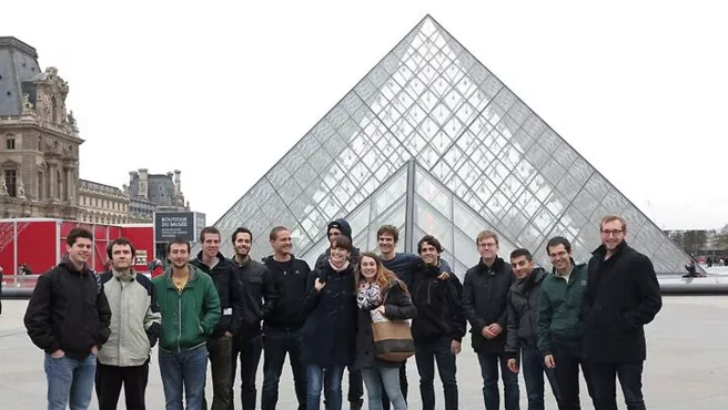 A group of people in front of the pyramid of the Louvre Museum in Paris