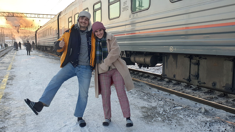 Zwei TUM-Studierende bei einem Zwischenstopp ihres Zugs in winterlicher Landschaft