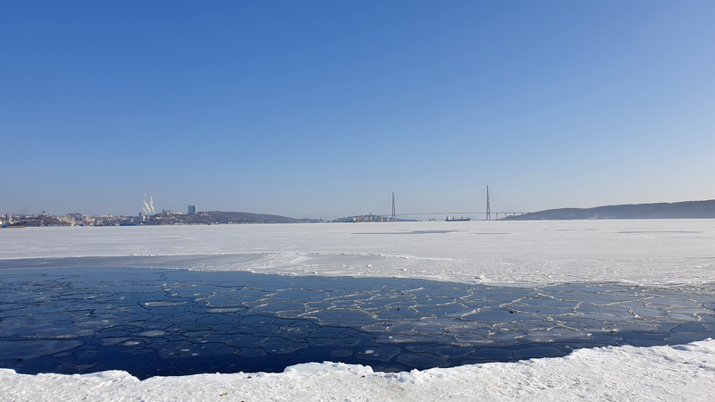 Zugefrorene Amur-Bucht mit Russki-Brücke im Hintergrund