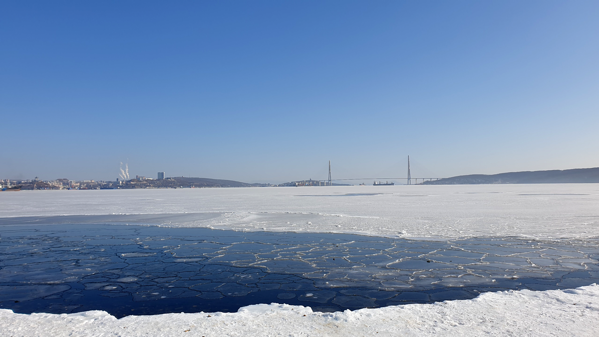 Zugefrorene Amur-Bucht mit Russki-Brücke im Hintergrund