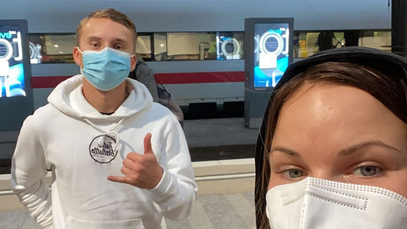 Two young people with face masks on a platform