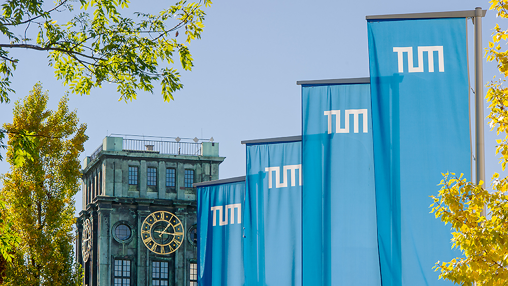 Flags of TUM in front of the Thiersch Tower at the main campus in Munich