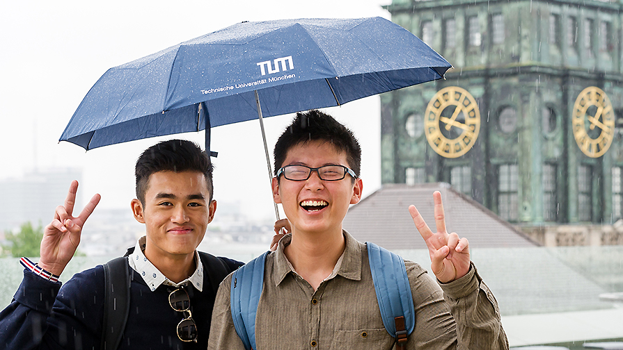Zwei asiatische Studenten mit TUM-Regenschirm