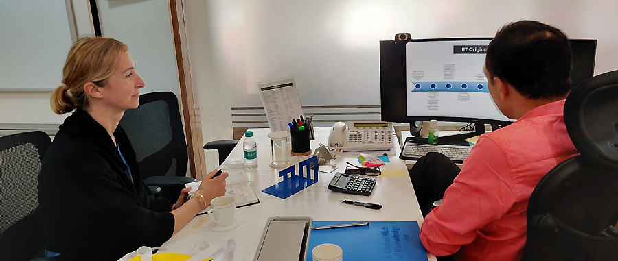 Two people talking in front of a computer screen