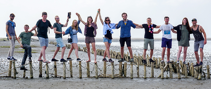 Eine Gruppe Studierender hält sich bei ihrem Ausflug auf die Dänischen Wattenmeerinseln an den Händen 