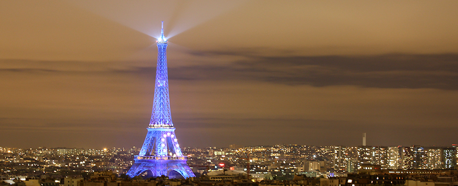 Blau leuchtender Eiffelturm mit Eurozeichen im nächtlichen Paris